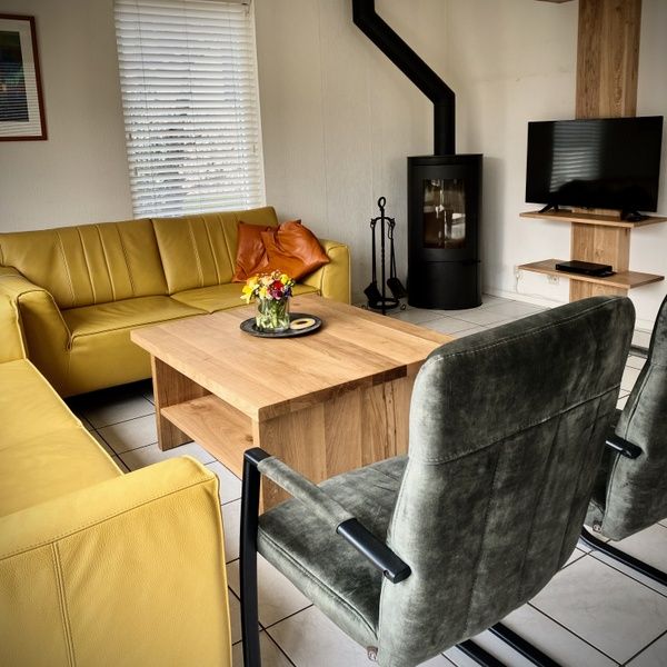 Cozy sitting area with fireplace in Stappeland - Huize 100-1, vacation home in De Koog, Texel, ideal for relaxation.