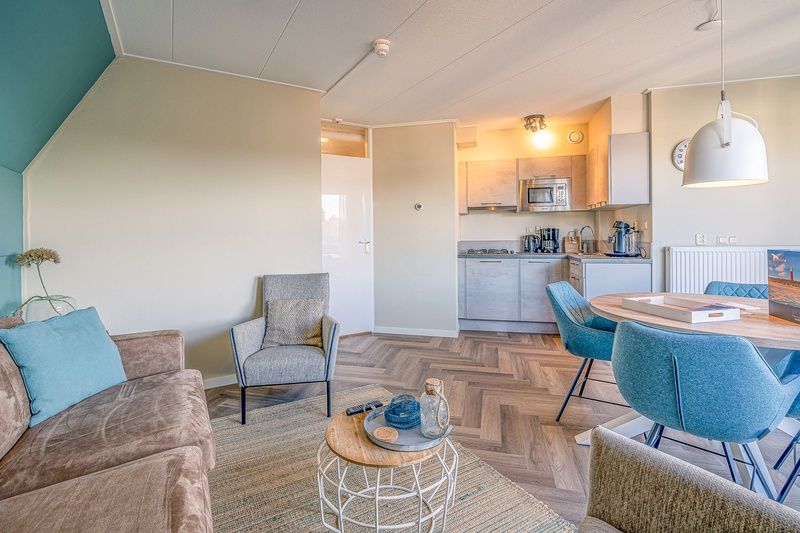 Dining room with round table in Apartment Zeedistel 22, De Koog, Texel with lots of natural light.
