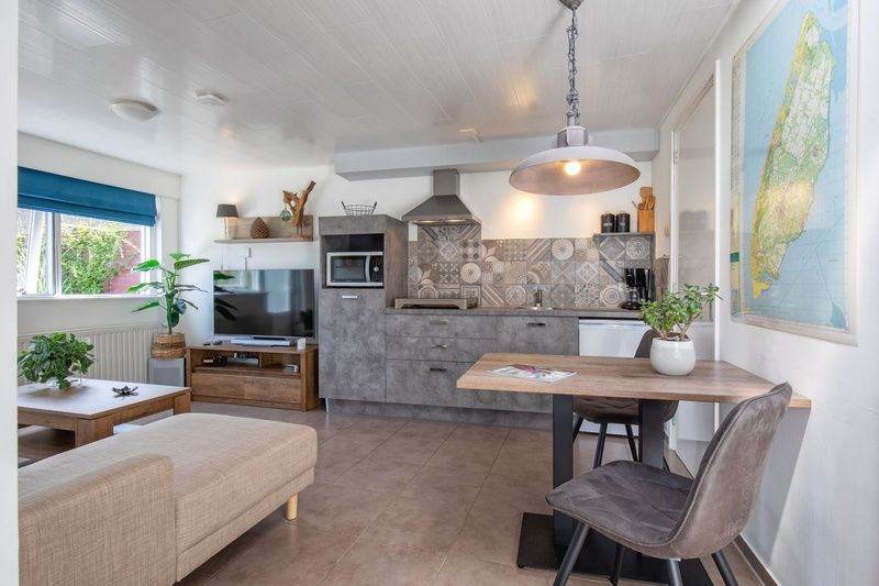 Open kitchen and dining area in Duo bungalow, vacation home in De Koog, Texel with modern amenities.
