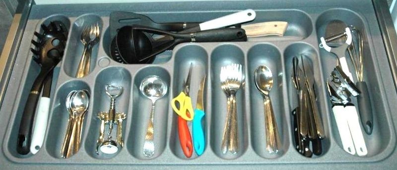 Well-equipped kitchen drawer in Duo bungalow, vacation home in De Koog, Texel with various cooking utensils.