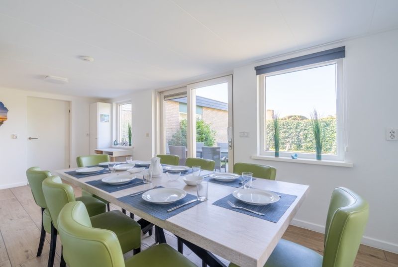 Stylish dining room in Orchismient 14 vacation home De Koog Texel with modern chairs and lots of natural light.