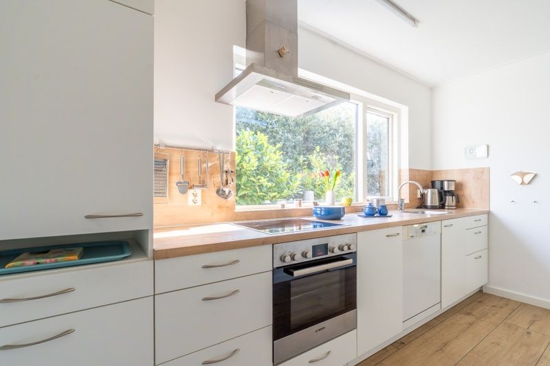 Modern kitchen in Orchismient 14 vacation home De Koog Texel overlooking green garden and all amenities.