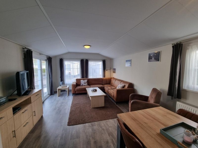 Spacious living space in Chaletpark Bregkoog - Chalet Bregkoog 235, De Koog, Texel with lots of natural light and access to terrace.