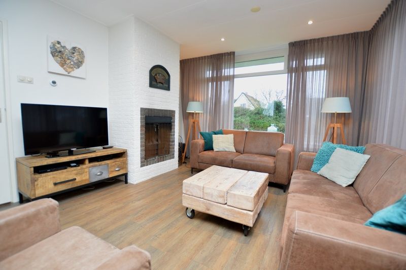 Epelaan 19 in De Koog, Texel, offers a cozy living room with a fireplace.