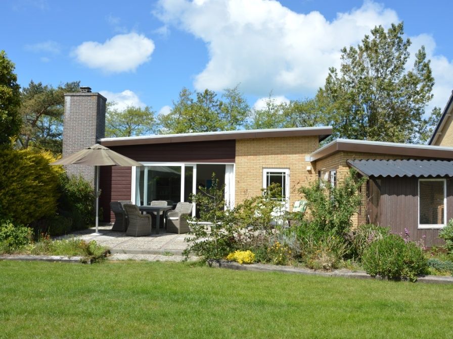 Epelaan 31 in De Koog, Texel offers a charming vacation home with an inviting terrace and green garden surroundings.