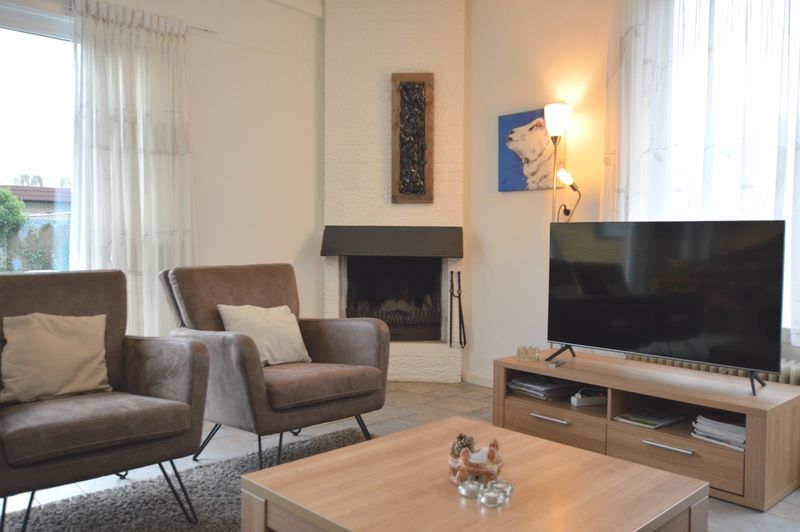 Comfortable sitting area with fireplace in Epelaan 31, vacation home in De Koog, Texel, ideal for relaxation.
