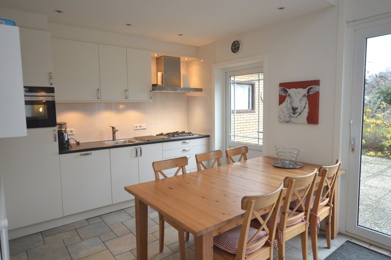 Modern kitchen in Epelaan 31, vacation home in De Koog, Texel, with dining area and outdoor access.