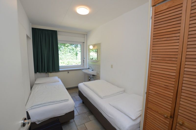 Attractive double bedroom in vacation home Epelaan 31, De Koog, Texel, with serene garden view.