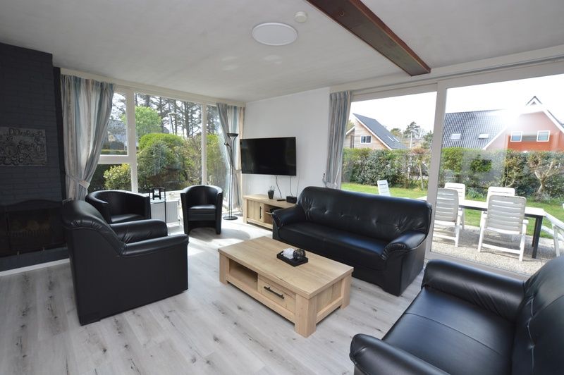 Ruime woonkamer in Orchismient 33 vakantiehuis De Koog Texel met uitzicht op tuin.