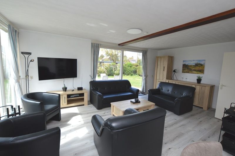 Lichte woonkamer in Orchismient 33 vakantiehuis De Koog Texel met tuinzicht.