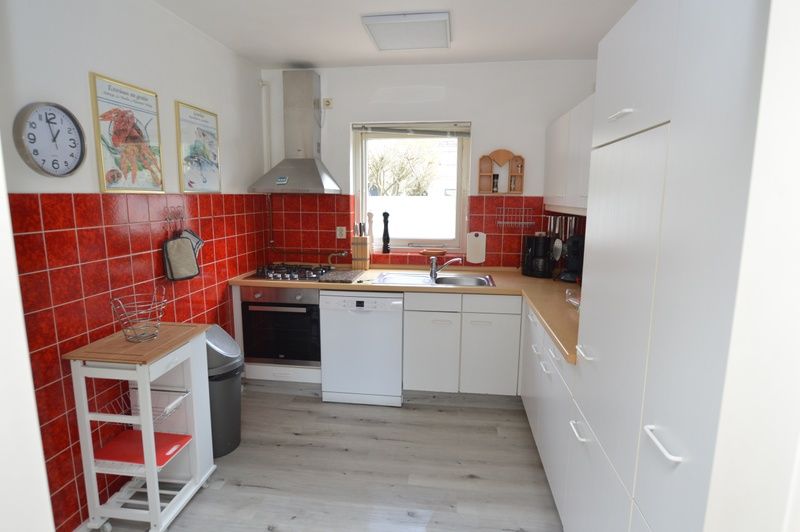 Moderne keuken in Orchismient 33 vakantiehuis De Koog Texel met rode tegels.