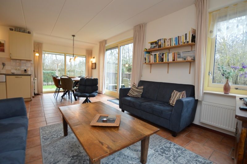 Open living room and dining area in Holiday home 7K, De Koog, Texel overlooking green surroundings, perfect for family vacations.
