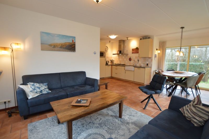 Vacation home 7K in De Koog, Texel offers a stylish living and dining area with access to the garden, ideal for a cozy stay.