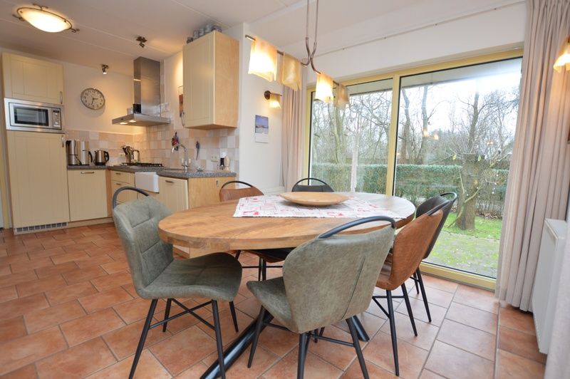 Dining area in Holiday home 7K, De Koog, Texel overlooking the garden, a perfect place to enjoy meals on the Wadden Islands.