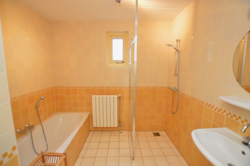 Modern bathroom in Holiday home 7K, De Koog, Texel with bathtub and shower, perfect for relaxing after a day on the island.
