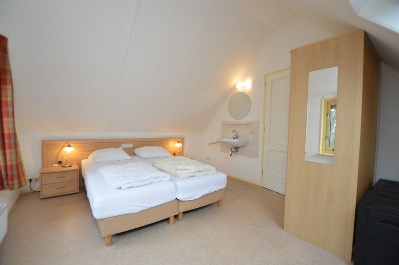 Spacious bedroom in Holiday home 7K, De Koog, Texel with double bed and private sink, ideal for a relaxing stay.