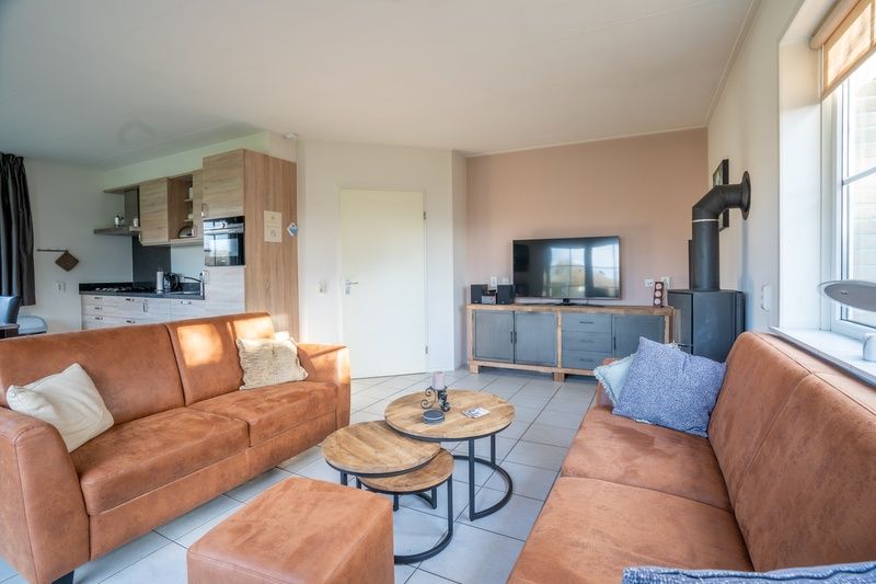 Open living space in Maaikeduinweg 13 vacation home, De Koog, Texel with modern kitchen and cozy sitting area for family stay.