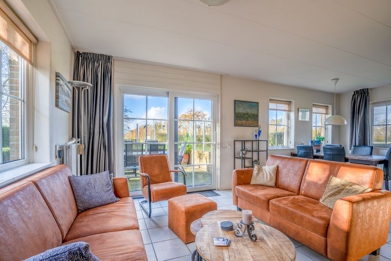 Bright living room in Maaikeduinweg 13 vacation home, De Koog, Texel with direct access to the terrace and views of nature.