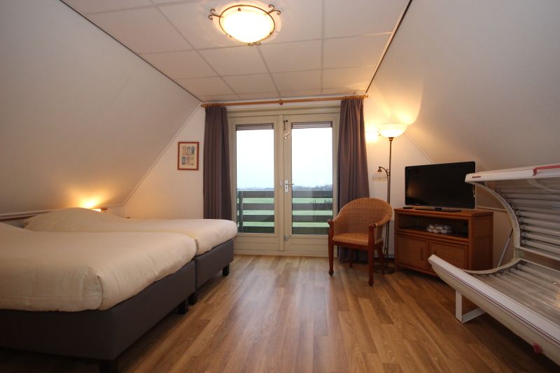 Tweede slaapkamer in Villa, De Koog, Texel, met balkon en uitzicht op de natuur van de Waddeneilanden.