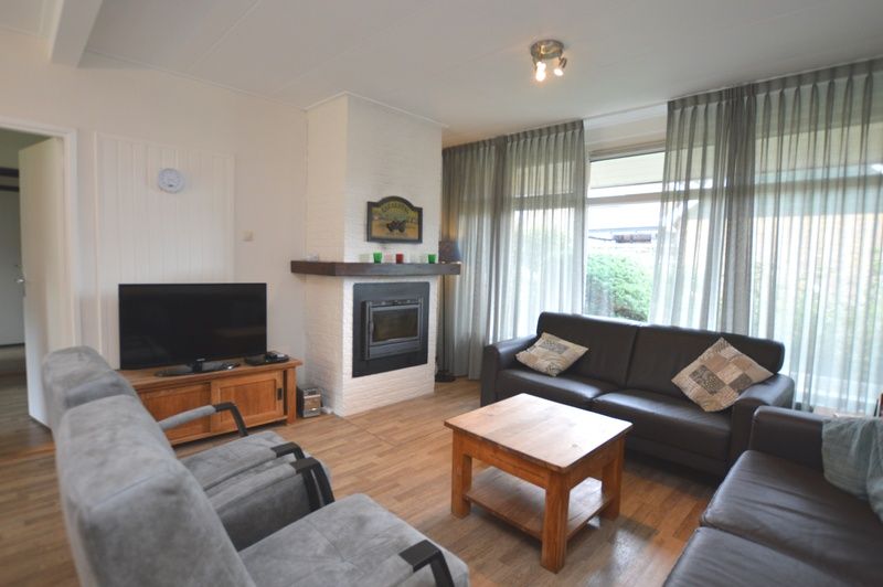 Cozy sitting area with fireplace in vacation home Orchismient 27, De Koog, Texel.