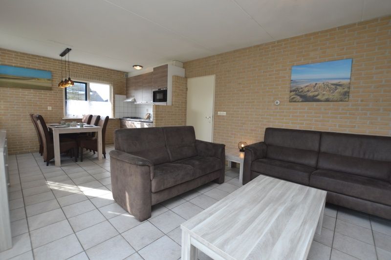 Modern decor in the living room of Holiday home Stappeland 207, De Koog, Texel with access to the kitchen.