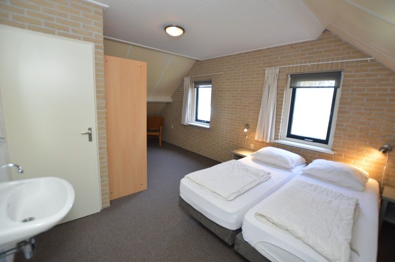 Spacious bedroom on the upper floor of Holiday home Stappeland 207, De Koog, Texel with extra sitting area.