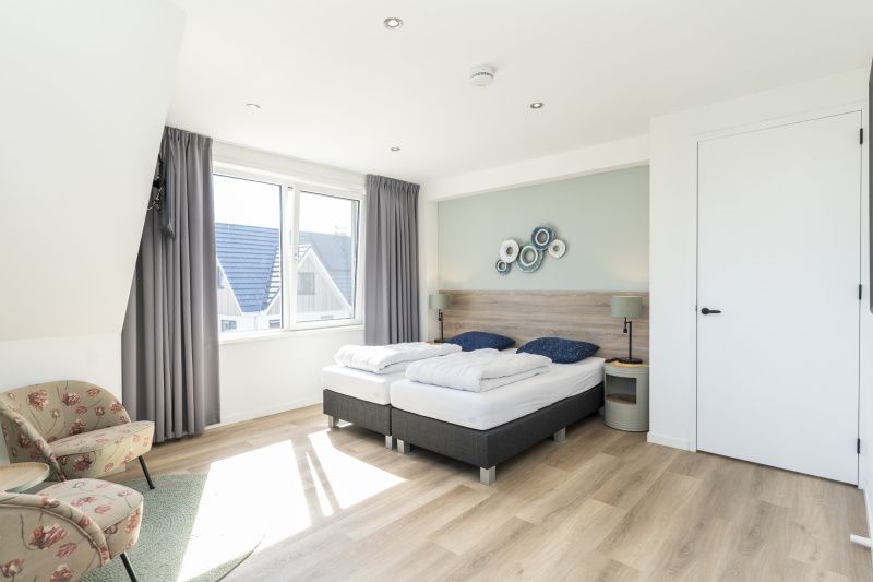 Second bedroom in Villa 37a, De Koog, Texel, vacation home with large window and comfortable bed.