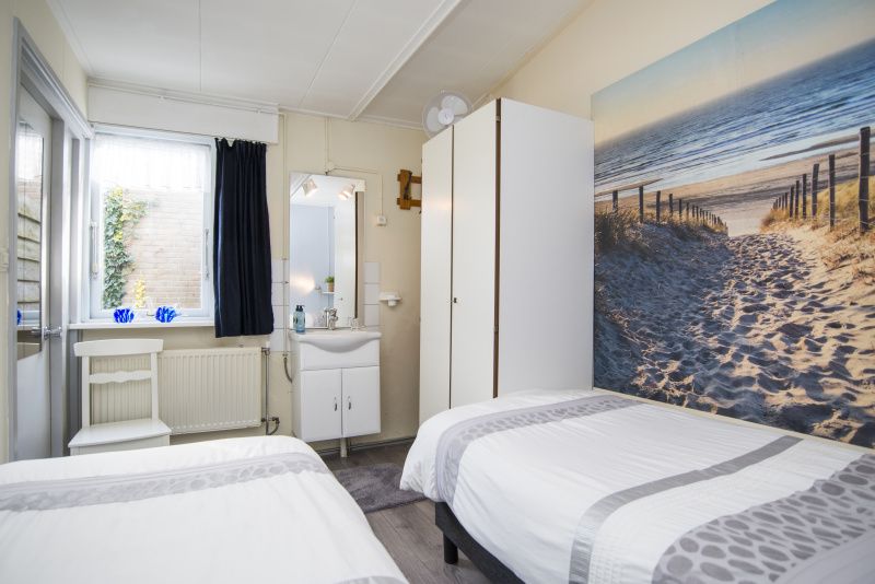 Bedroom in Bungalow 9708, De Koog Texel, with double beds and beach-themed decor.