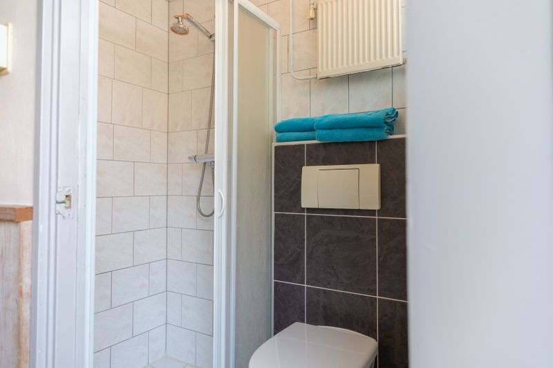 Modern bathroom in Bungalow 9708, De Koog Texel, with shower and fresh towels.