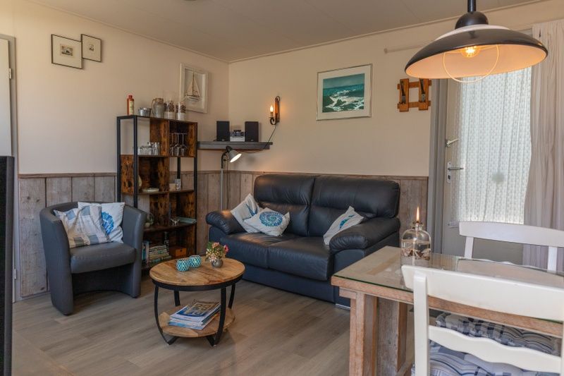 Stylish living room in Bungalow 9708, De Koog Texel, with sitting area and atmospheric lighting.