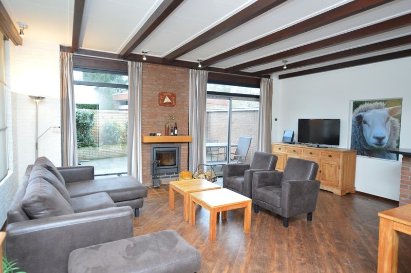 Cozy living room of Orchismient 28 De Koog Texel with fireplace and sitting area.