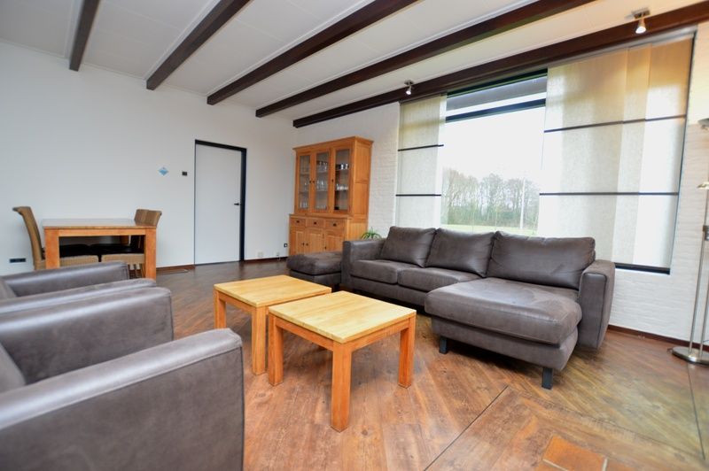 Spacious living room of vacation home Orchismient 28 De Koog Texel with wooden floor.