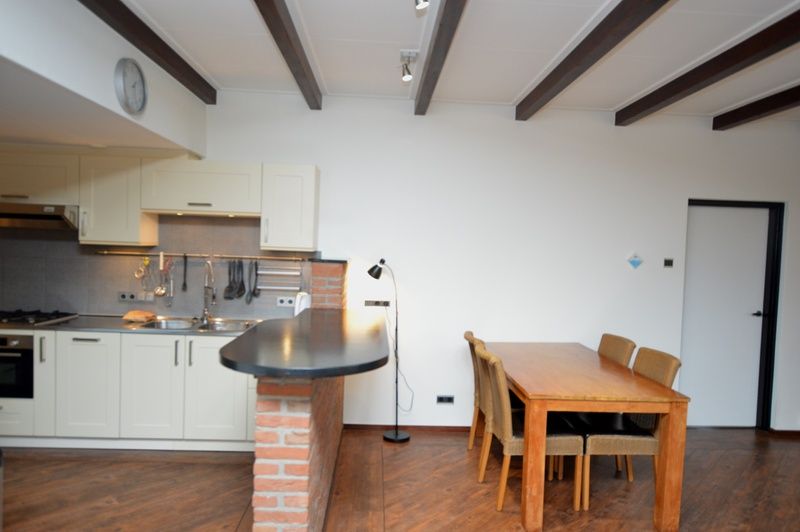 Dining area and kitchen in vacation home Orchismient 28 De Koog Texel with wooden furniture.