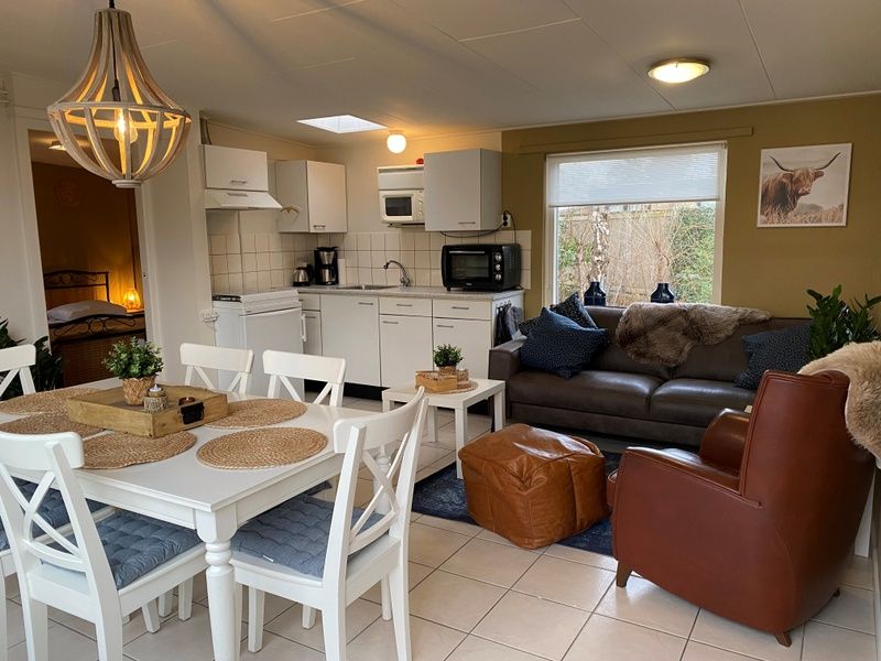 Modern kitchen and sitting area in Bungalow 51, Bungalowpark 't Luwe Land, De Koog, Texel, with comfortable furnishings.