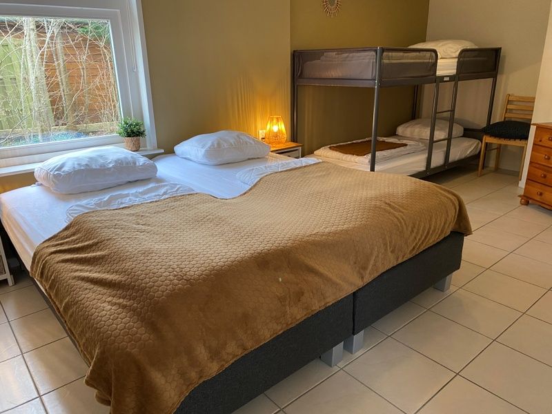 Family room with double bed and bunk bed in Bungalow 51, Bungalowpark 't Luwe Land, Texel.