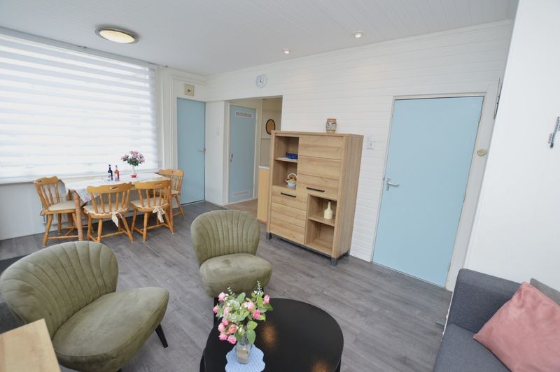 Spacious living room in Plevierstraat 18 vacation home, De Koog, Texel with sitting area and dining area.