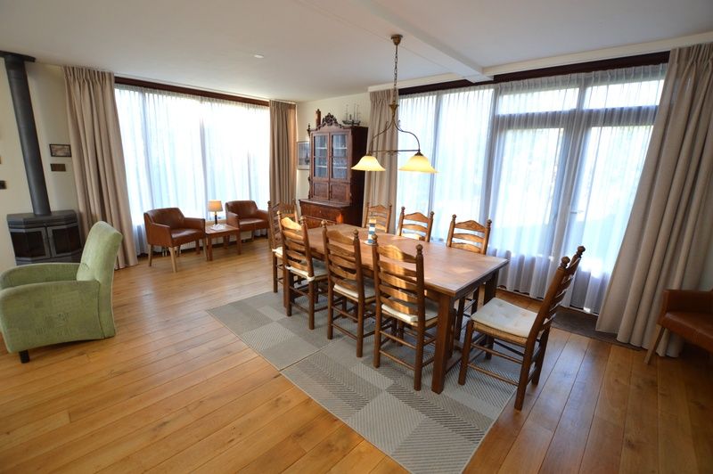 Spacious dining room in Orchismient 35 vacation home, De Koog Texel, with wooden floor and lots of light.