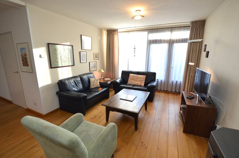 Comfortable sitting area in Orchismient 35 vacation home, De Koog Texel, with leather sofas.