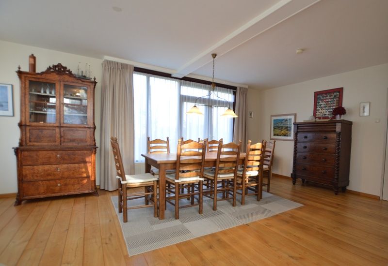 Large dining table in Orchismient 35 vacation home, De Koog Texel, with wooden chairs.