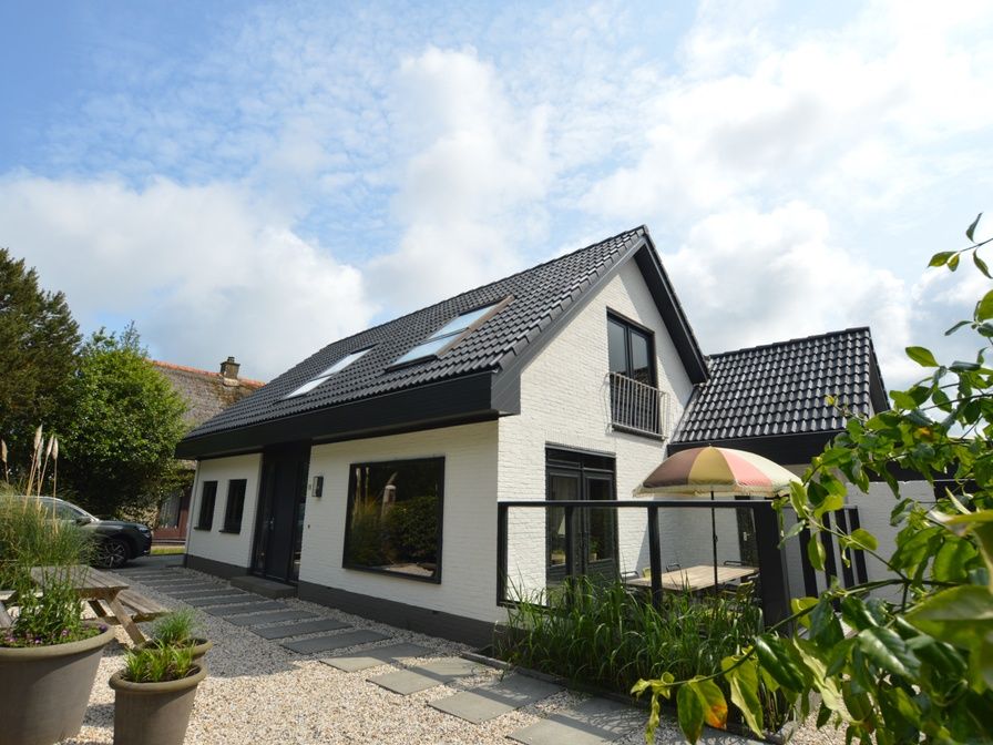 Ruijslaan 73, Ferienhaus in De Koog, Texel, mit schoener weisser Fassade und grossem Garten.