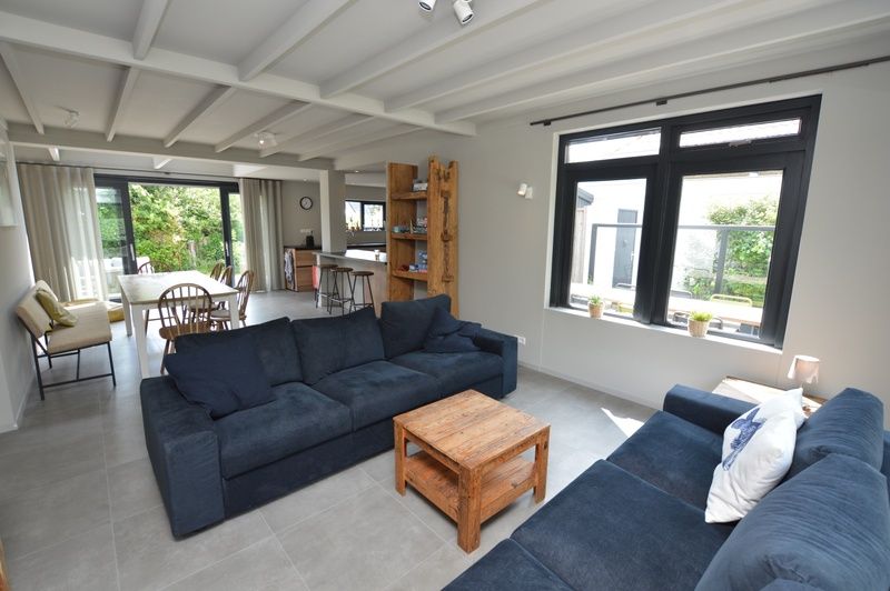 Geraeumiger, offener Wohnraum im Ferienhaus Ruijslaan 73, De Koog, Texel, mit moderner Einrichtung.