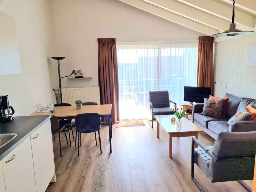 Gezellige woonkamer Motel Texel Appartement (Z) in De Koog, Texel met veel lichtinval en comfortabele zitplekken.