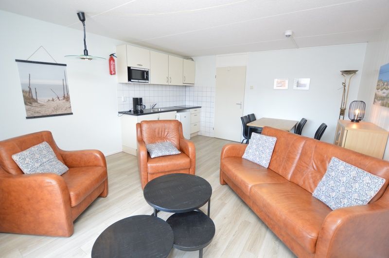 Offene Kueche im Motel Texel - Apartment 208/1L, De Koog, Texel, mit modernen Geraeten und einer gemuetlichen Sitzecke.