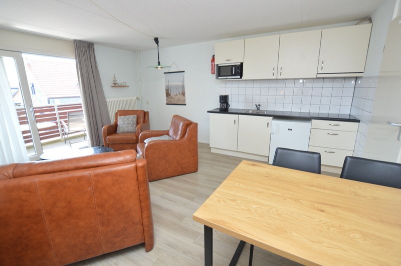 Kueche und Wohnzimmer im Motel Texel - Apartment 208/1L, De Koog, Texel, mit Zugang zu einem sonnigen Balkon.