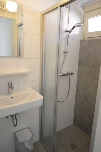 Modernes Badezimmer im Motel Texel - Apartment 208/1L, De Koog, Texel, mit einer geraeumigen Dusche und einem Waschbecken.