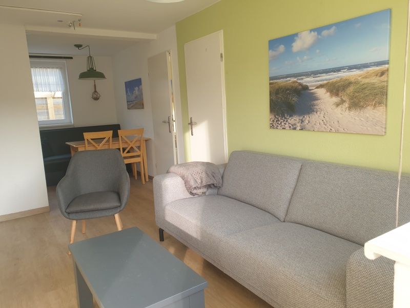 Cozy living room in De Duinpan - Duinhuisje Texel, De Koog, with comfortable seating and beach decor.