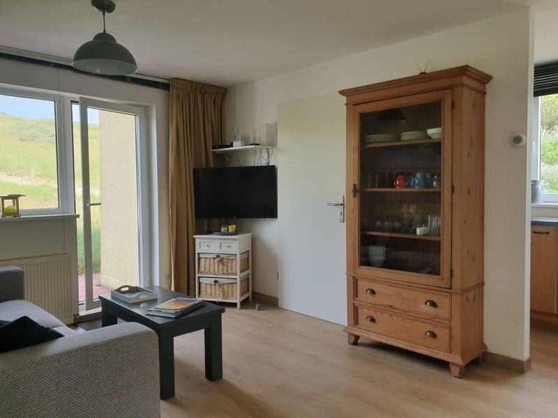 Cozy living space in De Duinpan - Duinhuisje Texel, De Koog, with wooden cupboard and modern furnishings.