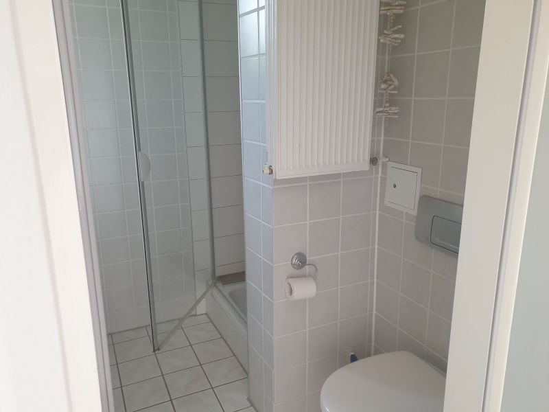 Fresh bathroom in De Duinpan - Duinhuisje Texel, De Koog, with shower cabin and neat finish.
