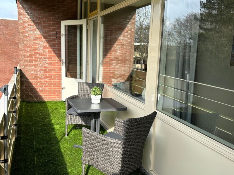 Sunny balcony of Apartment Kerckeland 40, De Koog, Texel with seating.