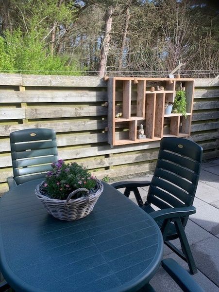 Outdoor area Chalet Bregkoog 203 in De Koog, Texel with garden furniture and wooden fence.